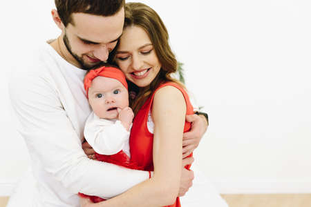 Beautiful caucasian family of three: mother, father and cute baby daughterの写真素材