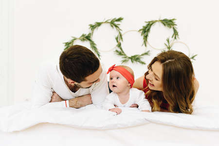 Beautiful caucasian family of three on bedの写真素材