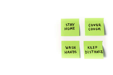 4 official precautions and preventive measures to follow on sticky post notes isolated on white background: stay home, wash hands, cover cough and keep distance in global coronavirus covid-19 pandemicの写真素材