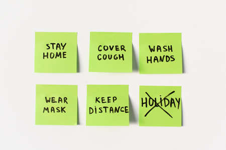Official precautions and preventive measures to remember on sticky post notes isolated on white background: stay home, wash hands, cover cough and keep distance in global coronavirus covid-19 pandemicの写真素材
