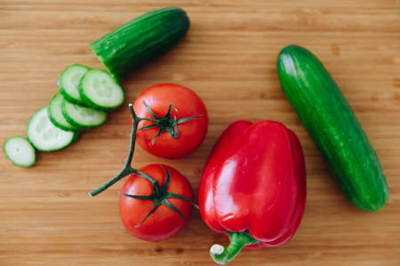 Top down view of fresh ingredients for a salad: bell pepper, tomatoes, cucumbersの写真素材