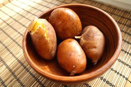 potatoes in bowl on wooden table with copy space, top viewの写真素材