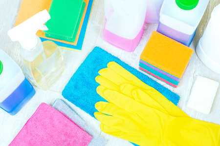 House cleaning supplies close up on wooden background. Gloves, sponges and rags.の写真素材