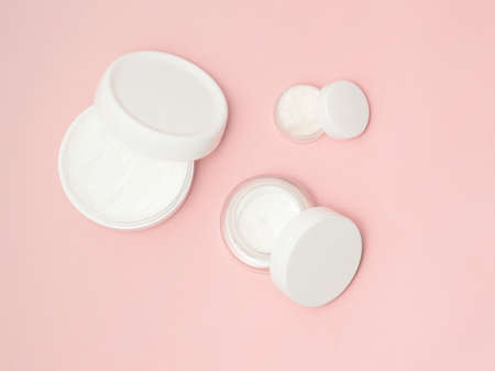White cream containers top view on pink backgroundの写真素材
