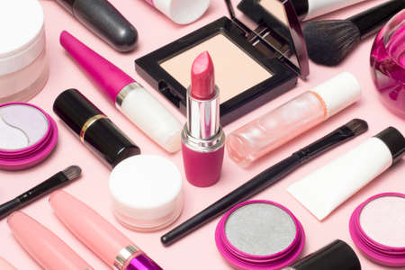Set of makeup cosmetics, concealer, brushes and other essentials on pink backgroundの写真素材