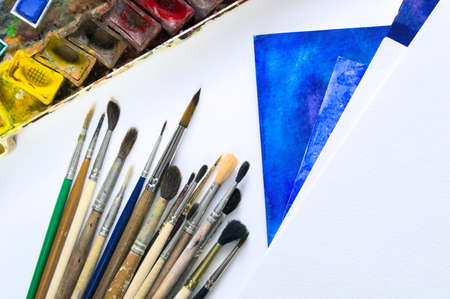 Close Up of desk with paper, watercolor and brushes. Variety colors.の写真素材
