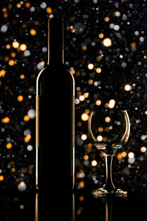 festive Christmas background with lights and silhouettes of a bottle and a glass on a dark backgroundの写真素材