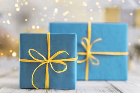 festive background with three gift boxes wrapped in blue paper and tied with yellow ribbon. High quality photoの写真素材