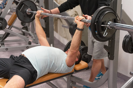 a middle-aged man works out in the gym with a barbell