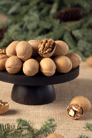 walnuts on a rustic stand with spruce branches in the background