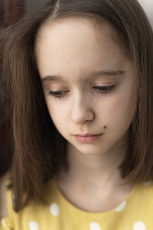 portrait of a beautiful sad teenage girl with a tear on her cheek