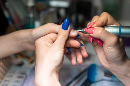 the procedure of a hardware manicure for a girl in a close-up in a beauty salon. High quality photo