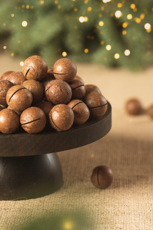 macadamia nuts on a rustic stand with spruce branches in the backgroundの写真素材