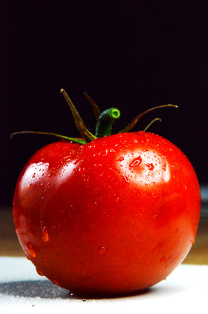 Fresh tomatoes in a white board on a dark background. Harvesting tomatoes. Top viewの写真素材