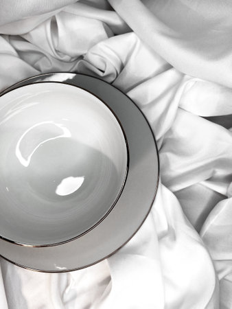 Tableware set of stack of white porcelain clean empty soup bowls on white textile background.の写真素材