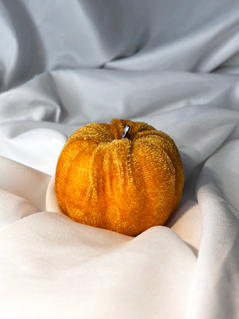 Fabric orange pumpkin on a white textile background. Top view. Halloween handmade pumpkins, sewing.の写真素材
