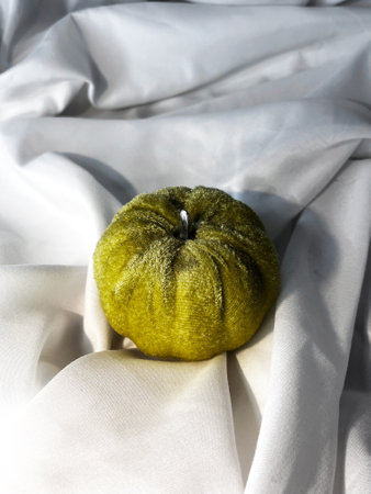 Fabric green pumpkin on a white textile background. Top view.の写真素材