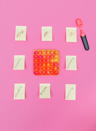 antistress toy on a pink background with yellow stickers.