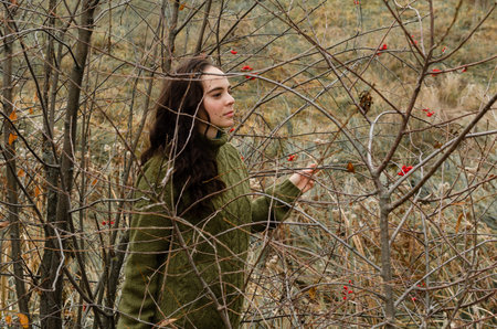 Dreamy brunette young woman stands in the forest surrounded by tree brunches. One with nature...