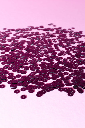 Black decorative sparkling sequins on pastel pink background. Copy space.