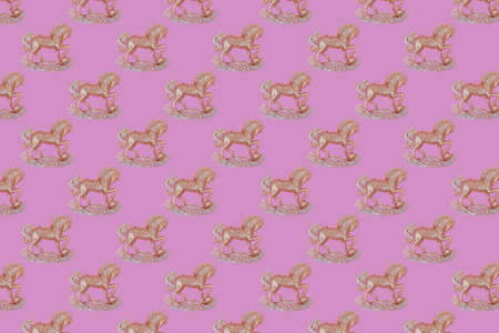 Christmas pattern of golden and silver sparkling horse decoration on a pink background with soft shadows.の写真素材