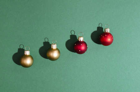 Top view of four red and gold Christmas decoration toy balls on a mint green background.の写真素材