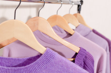 Closeup of fashionable tops in trendy purple, very peri, lavender colors on a shopping rail. Overconsumption, concept.の写真素材