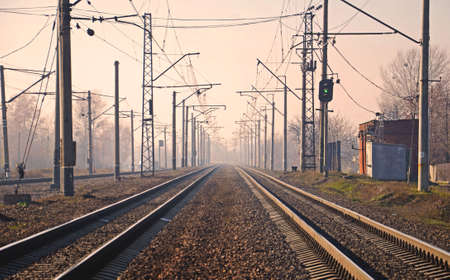 Railway tracks in the fog in the autumn at sunriseの写真素材