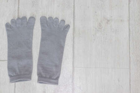 Gray non-slip yoga socks with toes on the floorの写真素材
