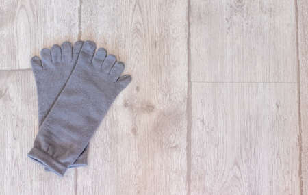 Gray socks with fingers on a wooden floor. Suitable for yoga.の写真素材