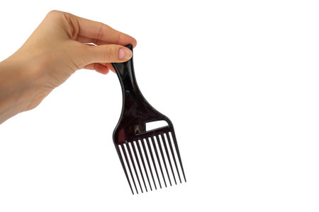 Afro Hair Pick, AfroPick black hair comb curly in a womans hand on an isolated white background.の写真素材