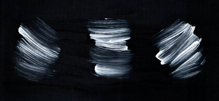 Matte black background with three large white brush strokes. Space for textの写真素材