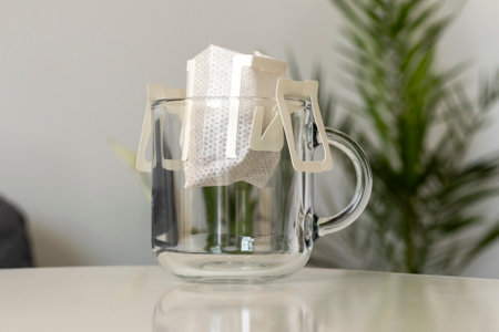 Opened bag of drip coffee in a clear cupの写真素材