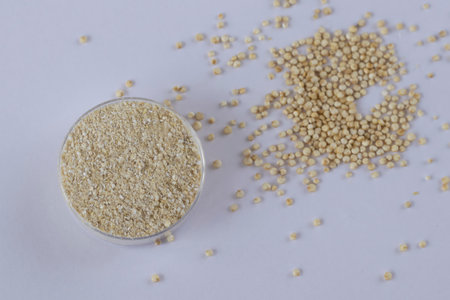 Gluten-free quinoa flour on white background next to grainsの写真素材