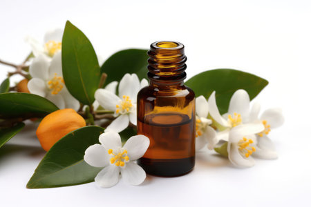 Neroli Essential Oil In Small Brown Bottle Next To Neroli On White Backgroundの素材
