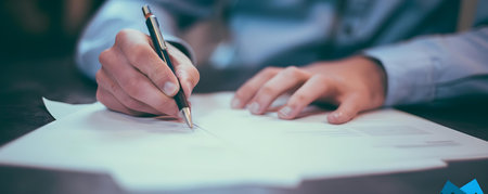 A man signing a contract with a pen in a closeup shot. Concept Business, Agreement, Contract, Signature, Closeup Shotの素材