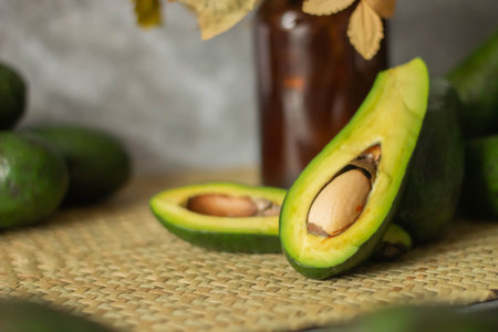 Avocado and avocado oil in glass bottle on wooden table background.の写真素材