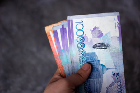 Hands holding a banknote of five thousand rubles against a dark background