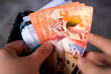 Close up of Thai banknotes in a black wallet, Thailand.