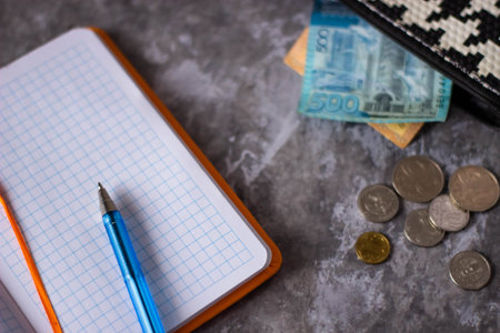 Pencil, notepad, money and wallet on a gray backgroundの写真素材