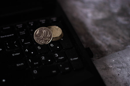 Close-up of euro coins on the keyboard of a laptop computer