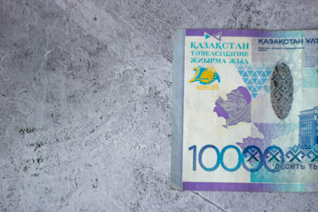 Banknotes of the Republic of Kazakhstan on a gray concrete background.