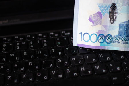 A closeup shot of a banknote on a black laptop keyboardの写真素材