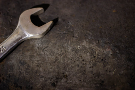 Wrench on a rustic metal background. Selective focus.