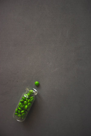 Green peas in a glass jar on a black background. Top view.の写真素材