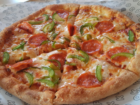 Pizza with pepperoni, jalapeno and cucumberの写真素材
