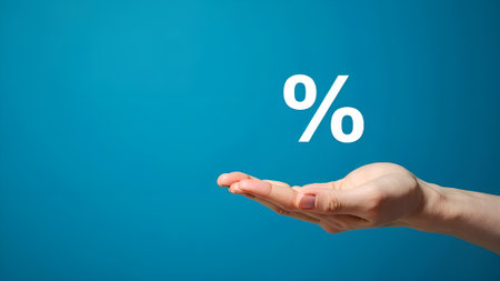 Percentage in hand on a blue background. Sale or discount conceptの素材