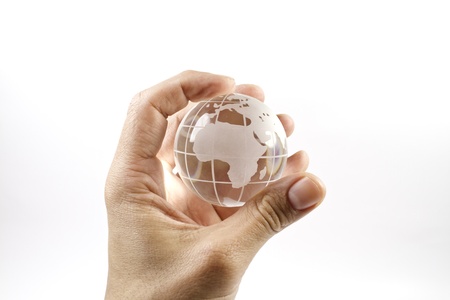 a hand holding a glass miniature of the worldの写真素材