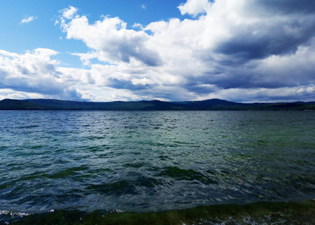 Summer landscape with a lake. Blue mountains against the background of the sky and the lake. Russia, Lake Turgoyak, Chelyabinsk region.の写真素材