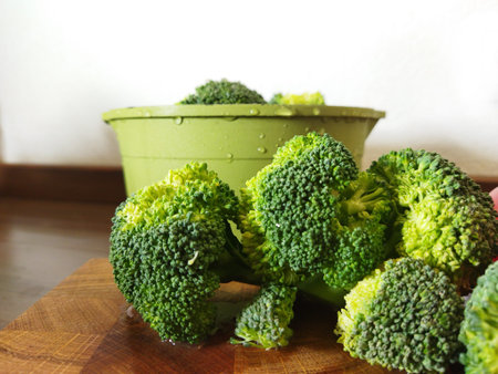 Close up broccoli on wooden table on kitchen. Health meal advertising. Green bright broccoli with...